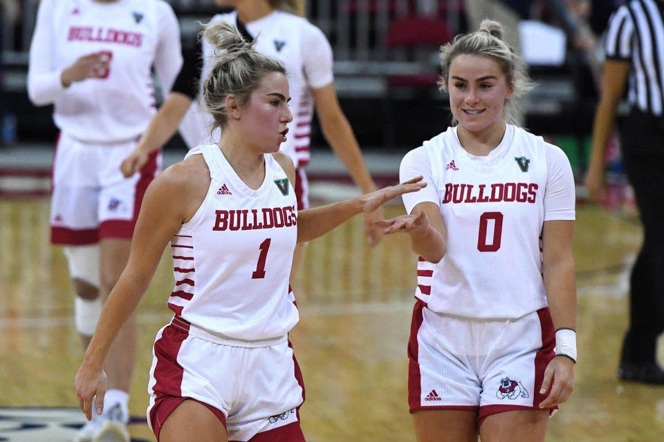 Fresno State's Haley Cavinder, left, with Hanna Cavinder, right, celebrate during an NCAA college basketball game game against Boise State on Jan. 23, 2021, in Fresno, Calif. It is a man's world six months after the NCAA cleared the way for college athletes to earn money on their celebrity. Men lead the way in total name, image and likeness compensation and have more NIL activities than women. (Eric Paul Zamora/The Fresno Bee via AP)