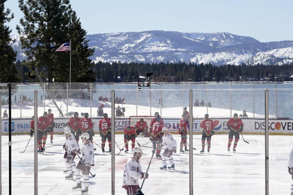 Members of the Colorado Avalanche, in white, and the Vegas Golden Knights, red, prepare to face off to start the first period of the Outdoor Lake Tahoe NHL hockey game in Stateline, Nev., Saturday, Feb. 20, 2021. (AP Photo/Rich Pedroncelli)
