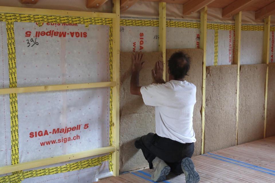 A construction worker installs insulation in a home.<span class="copyright">Universal Images Group via Getty Images</span>