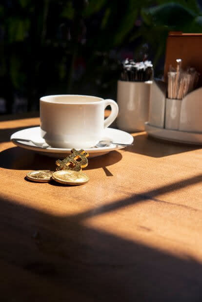 Kaffeetasse und Bitcoin-Münze