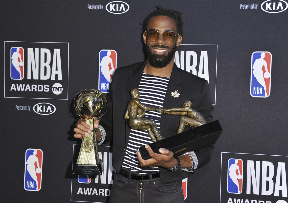 NBA player Mike Conley Jr., of the Memphis Grizzlies, poses in the press room with the NBA teammate award and sportsmanship of the year award at the NBA Awards on Monday, June 24, 2019, at the Barker Hangar in Santa Monica, Calif. (Photo by Richard Shotwell/Invision/AP)