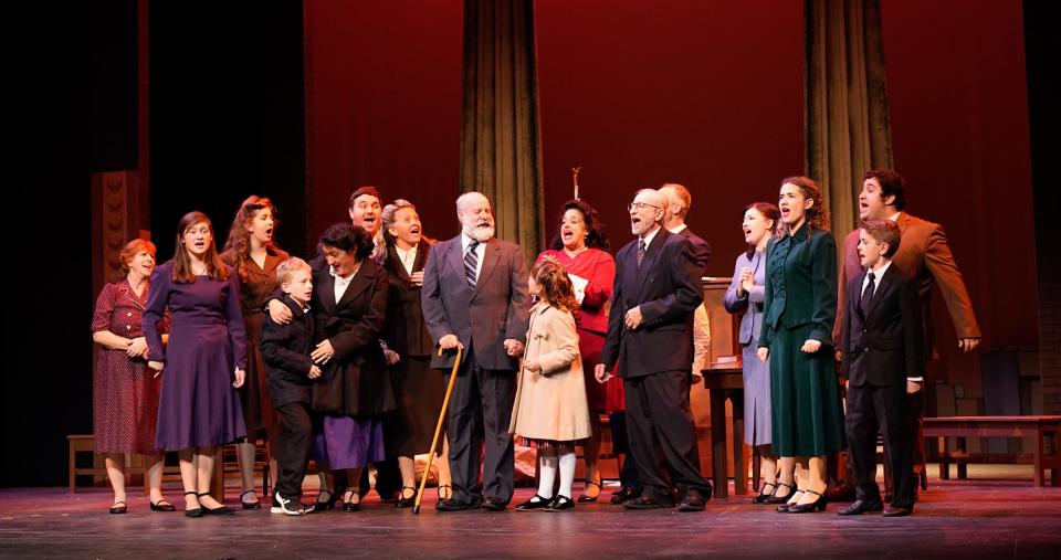 Mark Hyre as Kris Kringle, center, celebrates after proving he’s the real Santa Claus in a scene from “Miracle on 34th Street” at the Croswell Opera House.