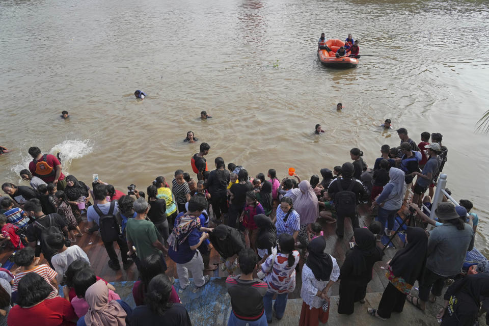 People bathe in the Cisadane River, ahead the holy fasting month of Ramadan in Tangerang, Indonesia, Tuesday, March 21, 2023. Muslims followed local tradition to wash in the river to symbolically cleanse their soul prior to entering the holiest month in Islamic calendar. (AP Photo/Tatan Syuflana)