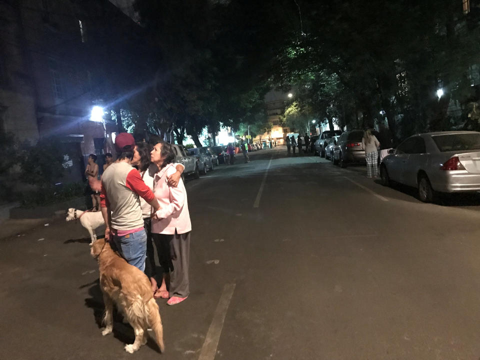 People react to an earthquake alert on a street in Mexico City