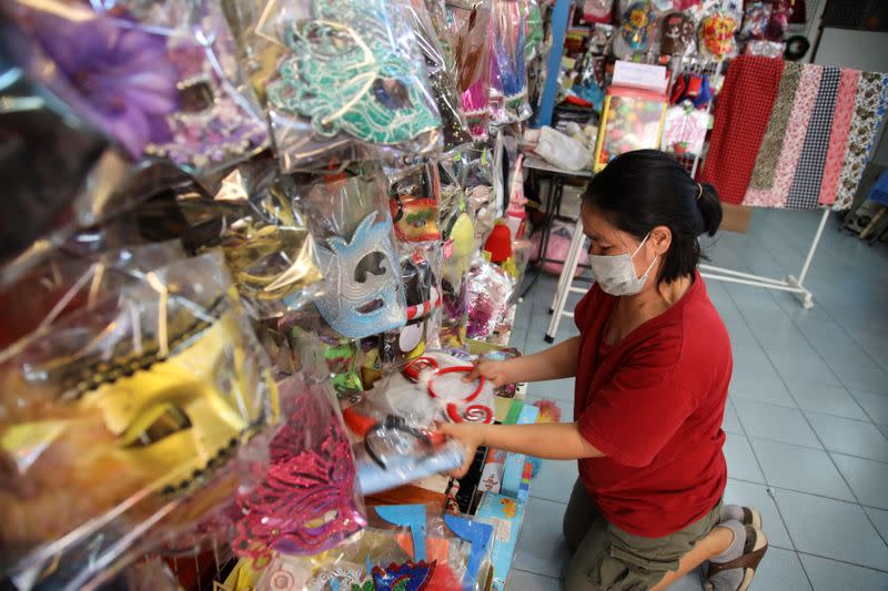 Lakkana Jaksin, a shop owner, arranges her souvenir gifts as she waits for tourists to shop at her shop in Phuket