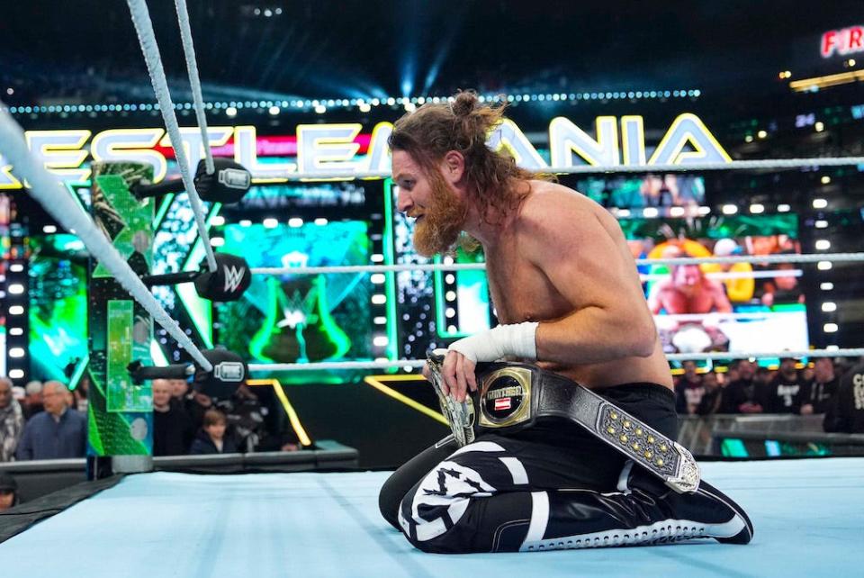Sami Zayn, pictured in the ring on his knees holding his belt after defeating GUNTHER to win the WWE Intercontinental Championship during Night One of WrestleMania 40 at Lincoln Financial Field on April 6, 2024 in Philadelphia, Pennsylvania.