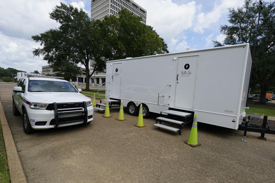 A Capitol Police SUV passes the portable toilets on the Mississippi State Capitol grounds, Wednesday, Aug. 31, 2022, in Jackson, Miss. The recent flood worsened Jackson's longstanding water system problems and the state Health Department has had Mississippi's capital city under a boil-water notice since late July. (AP Photo/Rogelio V. Solis)