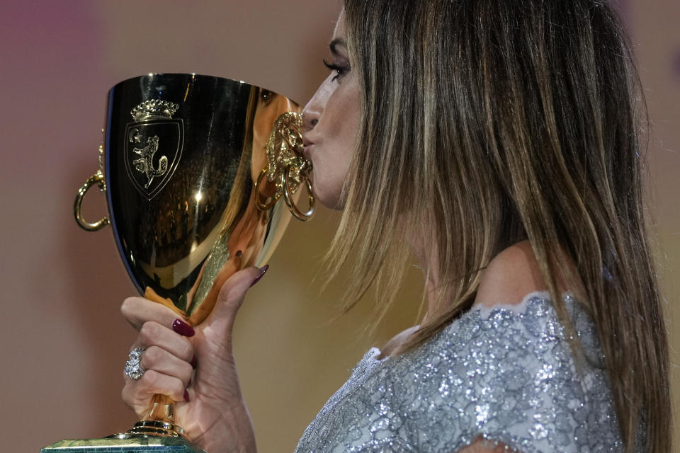 FILE - In this Sept, 11, 2021 file photo Penelope Cruz kisses the Coppa Volpi Best Actress award for 'Parallel Mothers' onstage at the closing ceremony during the 78th edition of the Venice Film Festival in Venice, Italy. (AP Photo/Domenico Stinellis, File)