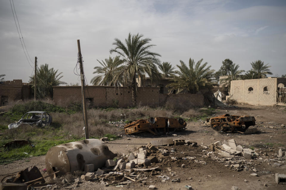 Damaged cars sit in an area recently retaken by U.S.-backed Syrian Democratic Forces (SDF) from Islamic State militants in Susah, Syria, Saturday, Feb. 16, 2019. (AP Photo/Felipe Dana)