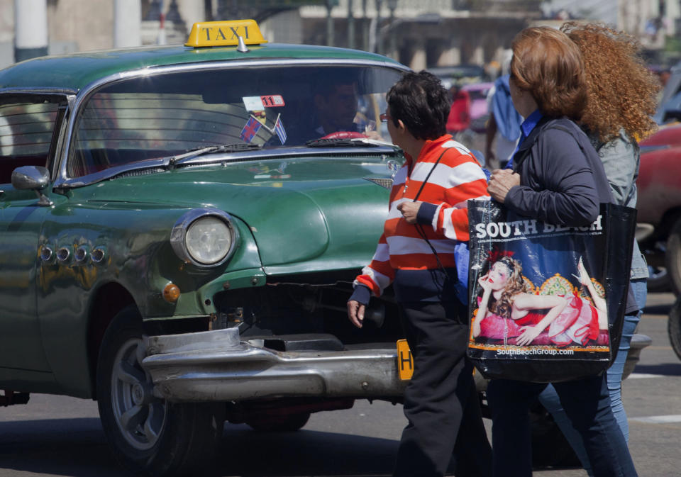 Women cross the street in front of moving traffic in Havana, Cuba, Monday, March 4, 2013. Cuban law prescribes jail time for motorists who kill pedestrians, even if they aren't speeding and the victim crosses improperly. (AP Photo/Ramon Espinosa)