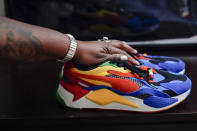 In this July 8, 2021, photo Latrice Felix places her hand on the last sneakers her son Alan Womack Jr. wore before he was killed in 2020 during a fight, in King of Prussia, Pa. (AP Photo/Matt Rourke)