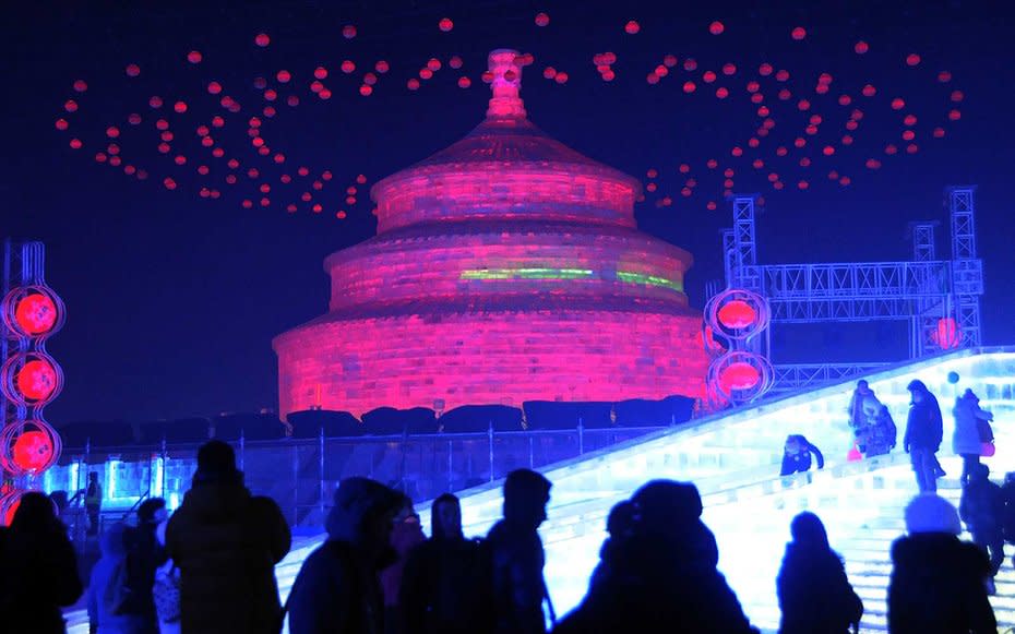 <p>Tourists visit ice sculptures illuminated by colored lights during the opening ceremony of theIce and Snow World as part of the 33rd Harbin International Ice and Snow Festival inChina.</p>