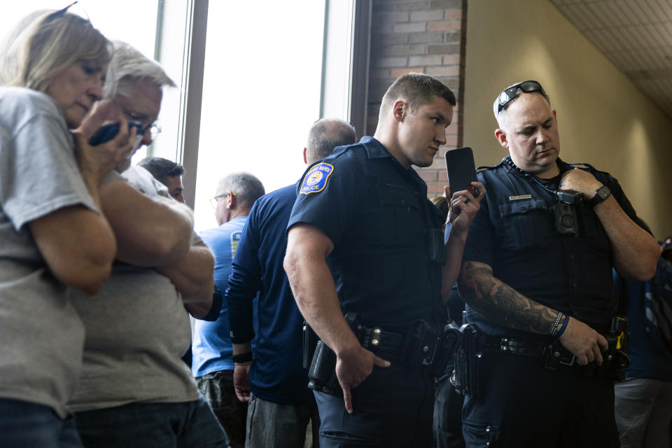 Supporters of Christopher Schurr gather in the hallway and listen on a live stream outside of Kent County District Court as Grand Rapids Police officer Schurr appeared on video from jail, Friday, June 10, 2022 in Grand Rapids, Mich. A judge facing a packed courtroom set bond Friday at $100,000 for Schurr, a Michigan police officer charged with second-degree murder in the death of Patrick Lyoya, a Black man who was shot in the back of the head in April. (Joel Bissell/The Grand Rapids Press via AP)