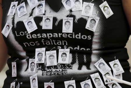 A protester takes part in a march calling for justice for 43 missing students, on the six-month anniversary of their disappearance, in Mexico City, March 26, 2015. REUTERS/Henry Romero