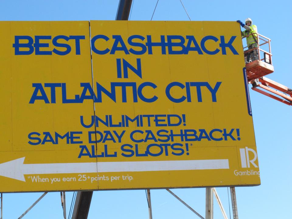 A worker in a cherry-picker lift prepares to demolish a large billboard on the Atlantic City NJ Boardwalk on Nov. 14, 2012. It was the first day of work on the $35 million Margaritaville entertainment complex at Resorts Casino Hotel. Construction crews started work on the project in what casino president Gary Van Hettinga called a vote of confidence in the seaside resort's long-term viability. (AP Photo/Wayne Parry)