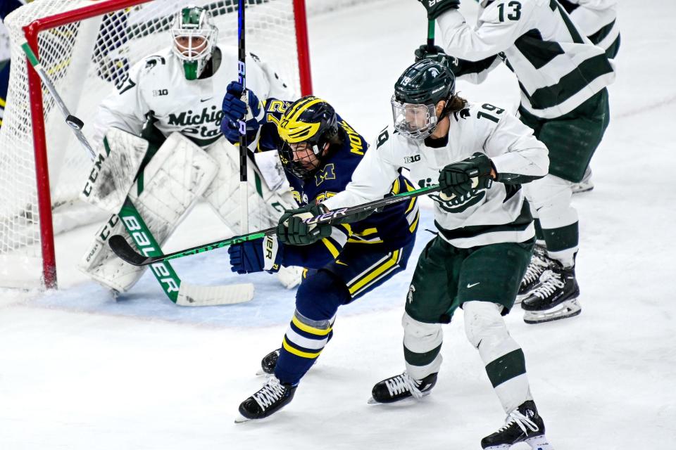 Michigan State's Nicolas MŸller, right, and Michigan's Nolan Moyle go after the puck during the first period on Friday, Dec. 9, 2022, at Munn Arena in East Lansing.