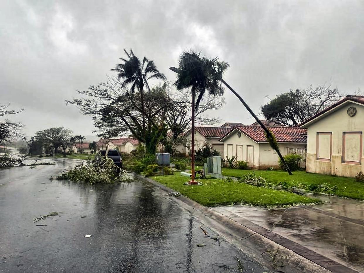 Downed tree branches litter a neighborhood in Yona, Guam (AP)
