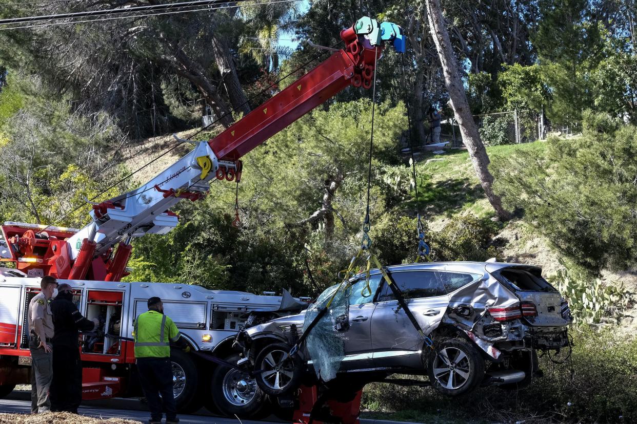 A crane is used to lift a vehicle following a rollover accident involving golfer Tiger Woods, Tuesday, Feb. 23, 2021, in the Rancho Palos Verdes section of Los Angeles.