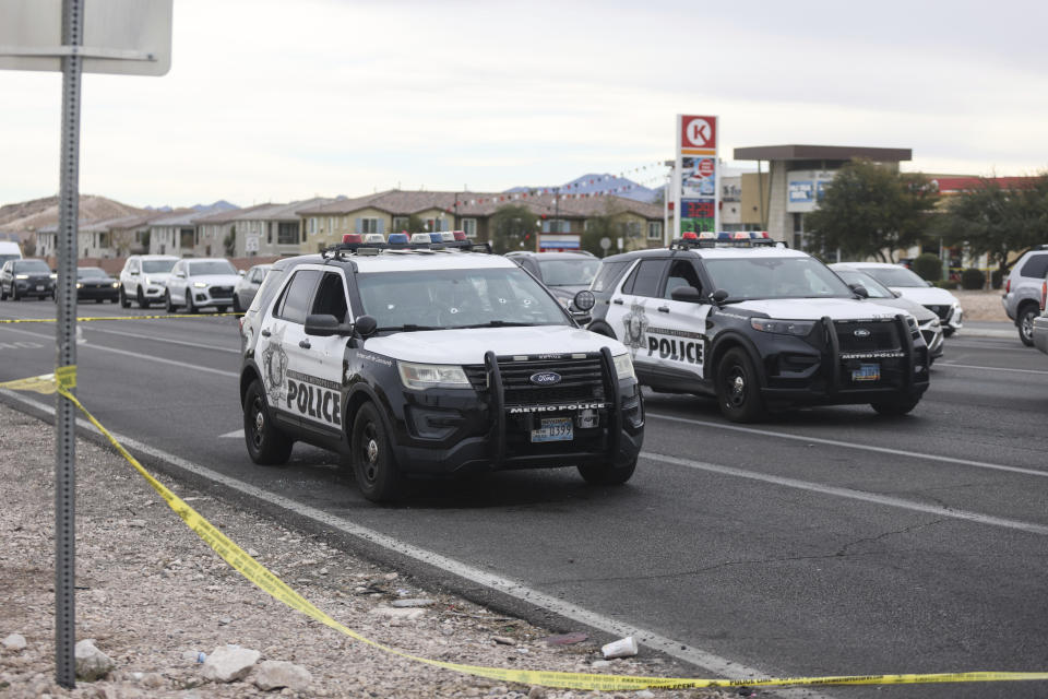 A police vehicle with bullet holes, left, is seen at the scene in the area of Blue Diamond Road and Durango Drive in Las Vegas, Wednesday, Dec. 27, 2023, after officers from two Nevada law enforcement agencies opened fire during a pre-dawn chase through Las Vegas as they tried to stop a man who fatally shot his mother, then stole a police cruiser and carjacked bystanders at gunpoint while trying to evade police, authorities said. (Rachel Aston/Las Vegas Review-Journal via AP)