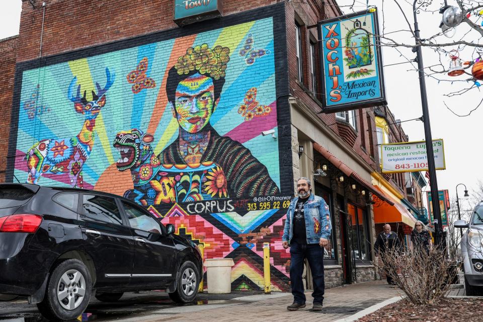 Elton Monroy Duran, 45, walks past the mural he painted of Frida Kahlo on the wall of Xochj’s Mexican Imports in Mexicantown, Detroit, on March 5, 2024. Duran plans to place his Alebrijes on the curbs along Bagley Street, right outside these businesses, in hopes of creating more of a sense of community celebrating their Mexican heritage.