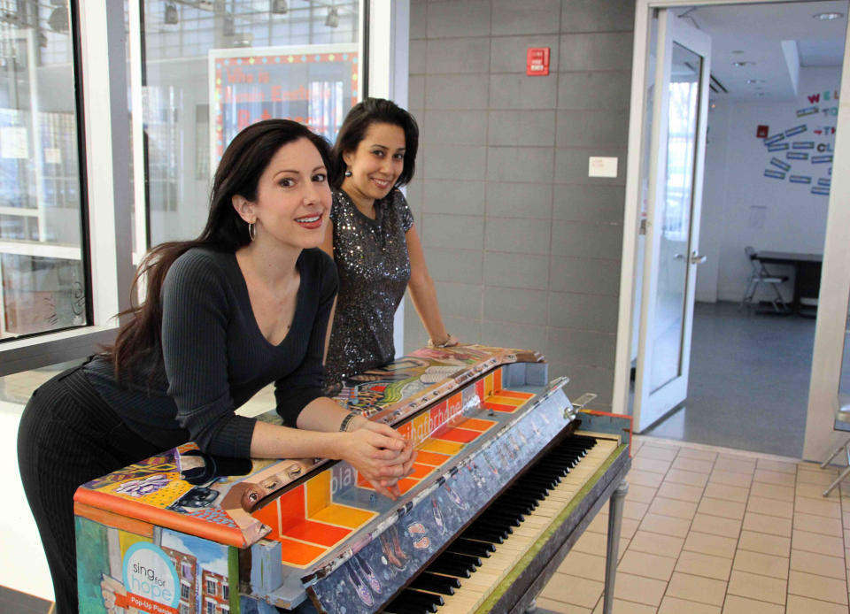 In this 2011 photo provided by Sing for Hope, Sing for Hope Co-Founding Directors Camille Zamora, left, and Monica Yunus lean on a piano decorated by artist Jillian Logue, after it found its final home in Betances Community Center in the Bronx borough of New York. A festival featuring 88 pianos planted all around New York City's streets and parks is returning this summer. It's called Sing for Hope Pianos and will run from June 1, 2013 through June 16. Each of the pianos will be painted and decorated by different artists.(AP Photo/Sing for Hope, Lekha Singh)