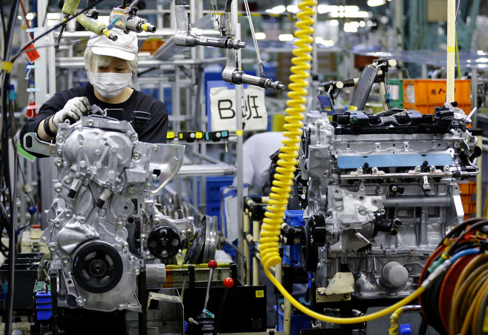 FILE - A Nissan Motor Co. factory worker checks an engine on an assembly line at its plant in Yokohama, near Tokyo, Aug. 2, 2017. (AP Photo/Shizuo Kambayashi, File)