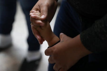 A woman holds a child's hand as undocumented immigrant families are released from detention at a bus depot in McAllen, Texas, U.S., June 22, 2018.  REUTERS/Loren Elliott