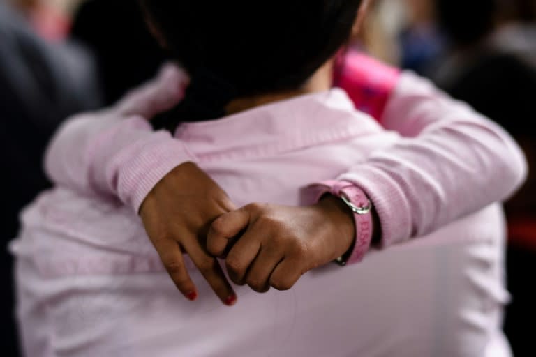 The hands of Keana, daughter of Filipino refugee Vanessa Rodel, are seen as she hugs her mother outside the Immigration Tower in Hong Kong