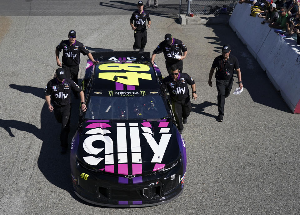 Crew members push Jimmie Johnson's car to the track during the NASCAR Cup Series auto race at Auto Club Speedway, in Fontana, Calif., Sunday, March 17, 2019. (AP Photo/Rachel Luna)