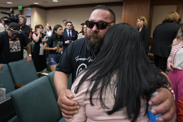Javier Casares hug his wife Gloria as they and other family members of the victims of the Uvalde shootings react after a Texas House committee voted to take up a bill to limit the age for purchasing AR-15 style weapons in the full House in Austin, Texas, Monday, May 8, 2023. (AP Photo/Eric Gay)