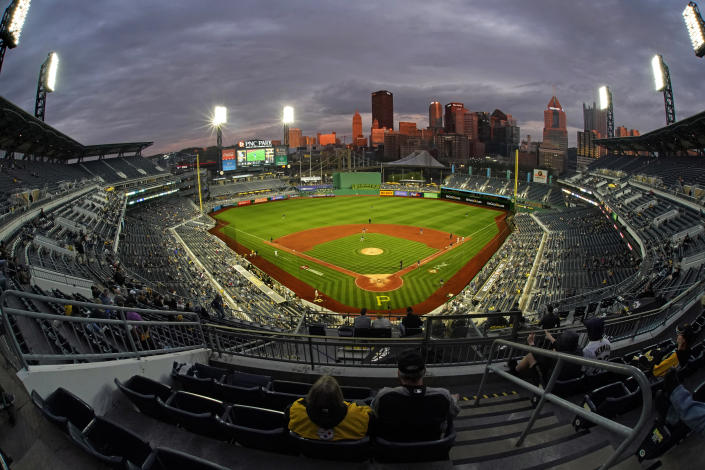The sun sets on downtown Pittsburgh as fans watch a baseball game between the Pittsburgh Pirates and the Colorado Rockies at PNC Park in Pittsburgh, Monday, May 23, 2022. (AP Photo/Gene J. Puskar)