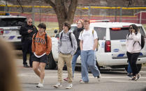 Students are walked out of East High School following a shooting, Wednesday, March 22, 2023, in Denver. Authorities say two school administrators were shot and wounded after a handgun was found during a daily search of a student at a Denver high school. The suspect remained at large. (AP Photo/David Zalubowski)