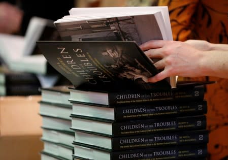 A woman looks at a copy of 'Children of the Troubles' at its launch in Londonderry, Northern Ireland