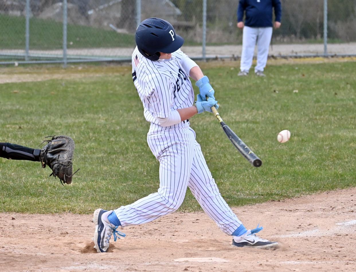 Petoskey junior Haden Janes swings into a pitch and drives it into center field during Tuesday's opener.