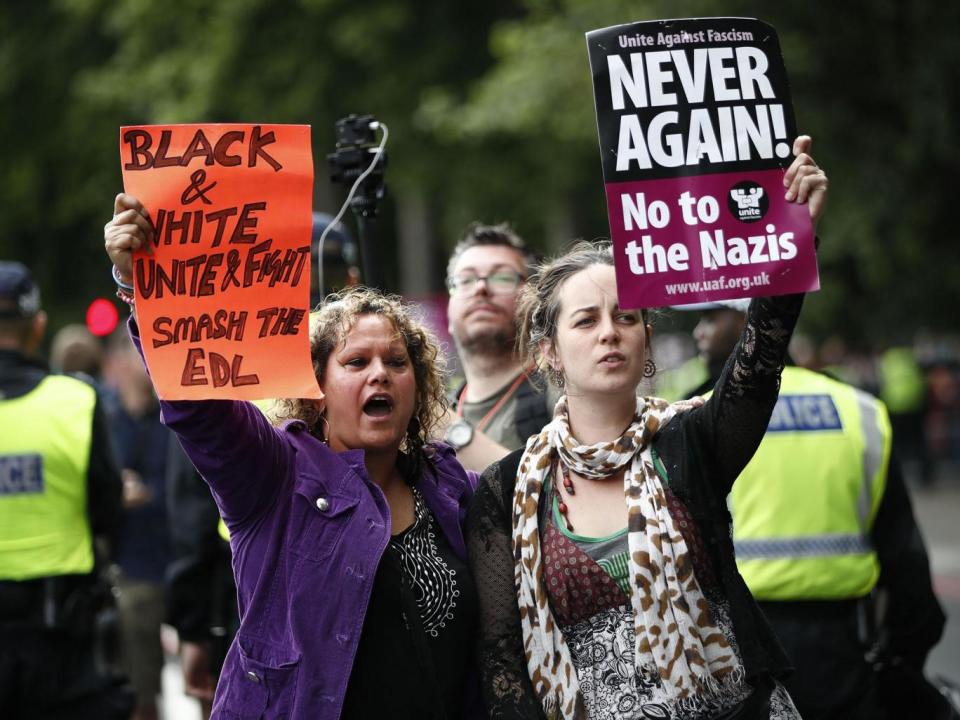 Counter-demonstrators hold up placards reading 'Never again! No to the Nazis' and 'black and white, unite and fight, smash the EDL' as the English Defence League (EDL) gather for a demonstration in central London (TOLGA AKMEN/AFP/Getty Images)