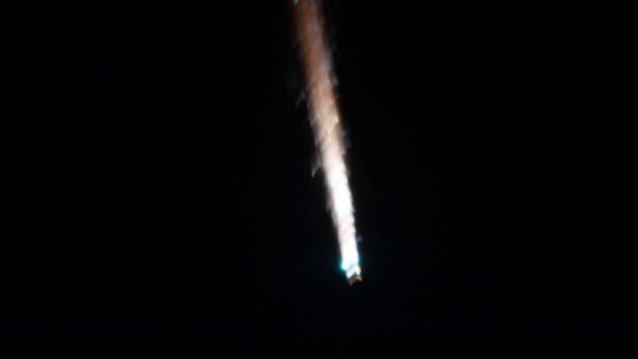  A trail of fire can be seen against a black background. 