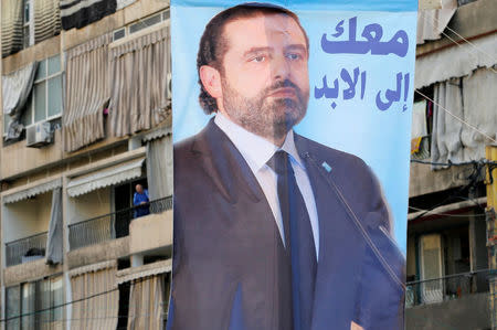 A poster depicting Lebanon's Prime Minister Saad al-Hariri, who has resigned from his post, hangs along a street in the mainly Sunni Beirut neighbourhood of Tariq al-Jadideh in Beirut, Lebanon November 6, 2017. The Arabic on the poster reads, "With you forever". REUTERS/Mohamed Azakir
