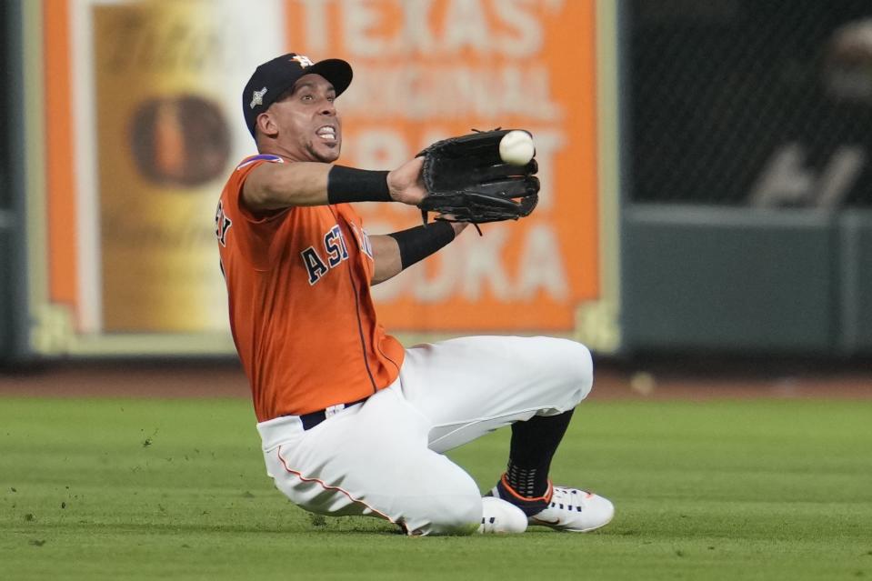 Houston Astros' Michael Brantley makes a sliding catch on a ball hit by Texas Rangers' Jonah Heim during the eighth inning of Game 6 of the baseball AL Championship Series Sunday, Oct. 22, 2023, in Houston. (AP Photo/Godofredo A. Vásquez)
