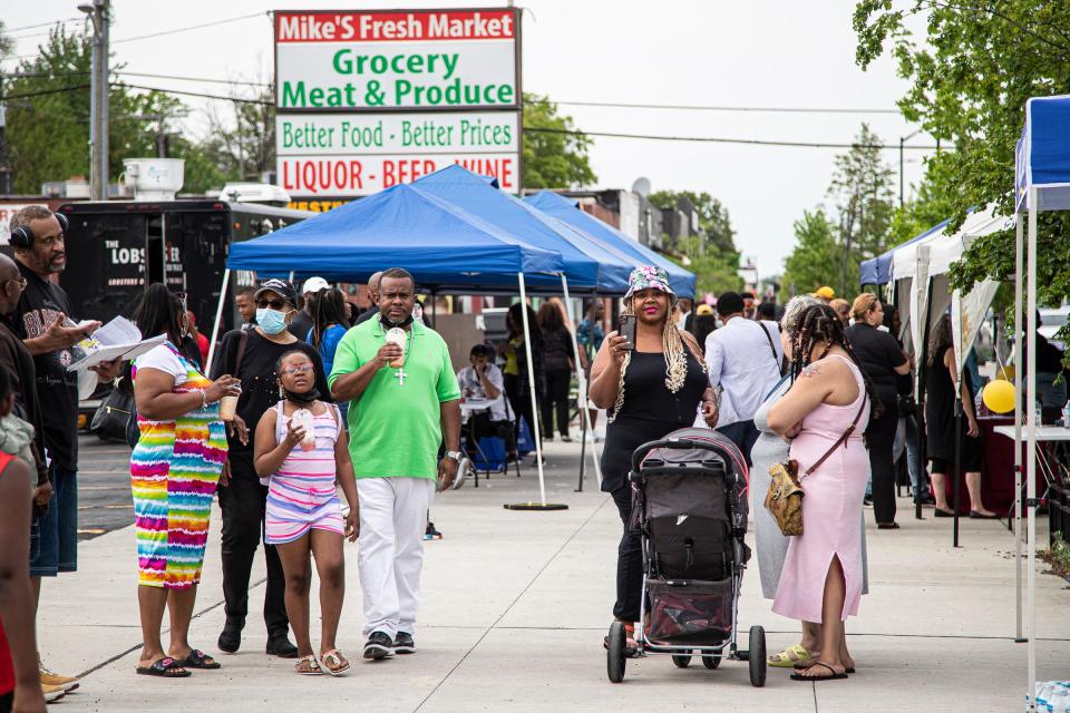 People walk down Livernois Avenue through vendors, during the Taste of Livernois as a part of Detroit Public Schools Community District's Alumni Weekend in Detroit on Saturday, May 21, 2022.