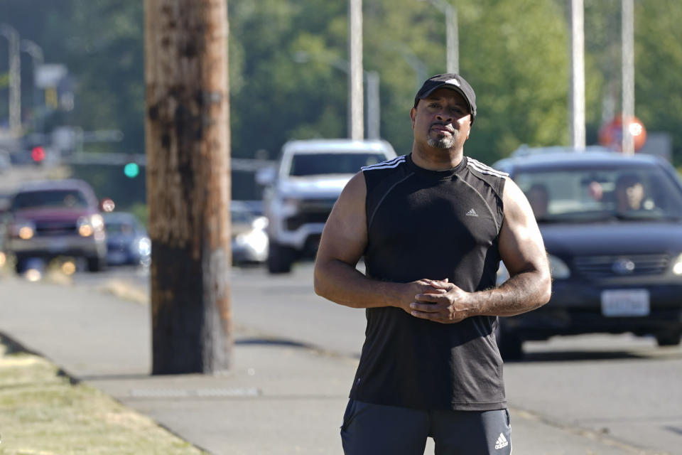 Dominique Davis, founder of Community Passageways, an organization that seeks to prevent community violence, poses for a photo, Tuesday, July 12, 2022 on Pacific Highway South, in Kent, Wash., south of Seattle, a roadway that Davis says has had multiple problems with shootings and other crimes for many years. The work of Davis' group falls under the umbrella of strategies known as community violence intervention, an approach backed by the Biden administration and donations from several major philanthropic foundations, which tries to stop local conflicts from escalating. (AP Photo/Ted S. Warren)