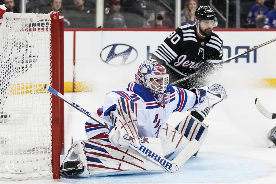 New Jersey Devils' Tomas Tatar (90) watches as New York Rangers goaltender Igor Shesterkin (31) protects his net during the second period of an NHL hockey game Thursday, March 30, 2023, in Newark, N.J. (AP Photo/Frank Franklin II)