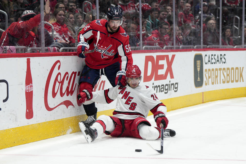 Carolina Hurricanes center Seth Jarvis (24) reaches for the puck as Washington Capitals defenseman Erik Gustafsson (56) defends during the third period of an NHL hockey game, Tuesday, Feb. 14, 2023, in Washington. The Hurricanes won 3-2. (AP Photo/Jess Rapfogel)