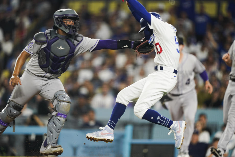 Colorado Rockies catcher Elias Diaz tags out Los Angeles Dodgers' Mookie Betts trying to steal home during the sixth inning of a baseball game Friday, Aug. 11, 2023, in Los Angeles. (AP Photo/Ryan Sun)
