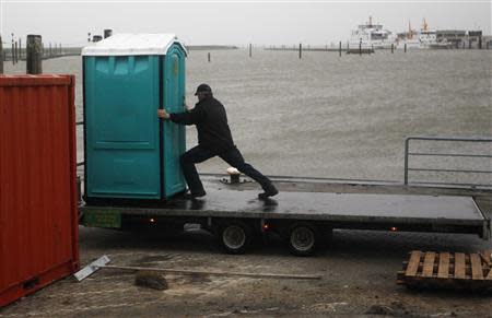 A man moves a mobile toilet on the North Sea beach near the town of Norddeich, December 5, 2013. REUTERS/Ina Fassbender