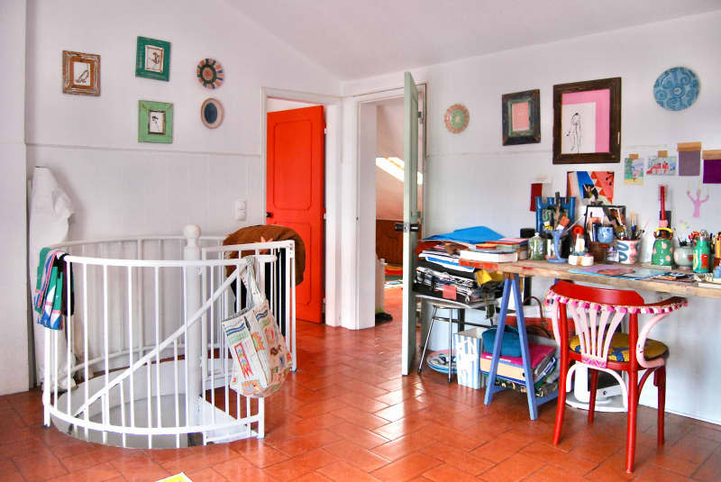 Art supplies on desk in white art room above spiral staircase.