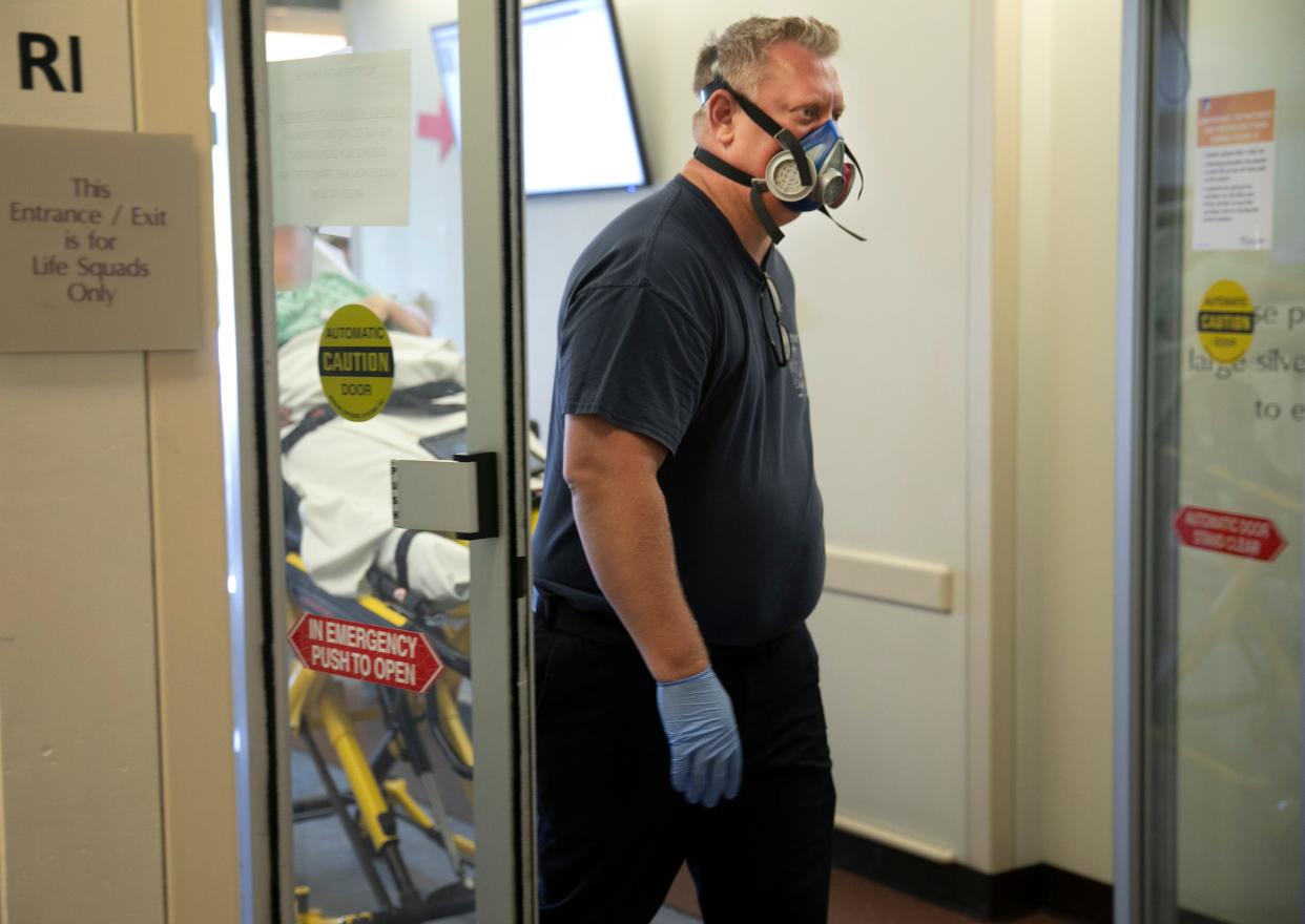 Chris Lakeberg, of the Cheviot Fire Department, brings a patient into the emergency room at The Christ Hospital, Friday, Aug. 21, 2020. Christ and other hospitals in the Cincinnati region have recently removed the requirement for guests to wear masks.