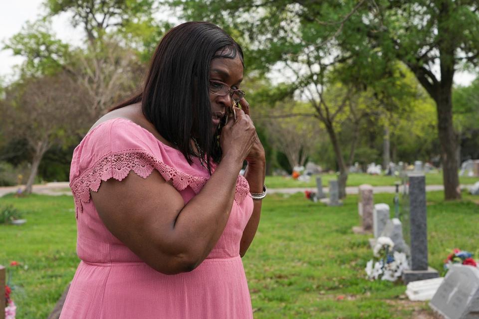 Carolyn White-Mosley wipes away tears while visiting the gravesite of her daughter, Ortralla Mosley, in East Austin nearly 20 years after her death on Monday, Feb. 6, 2023.