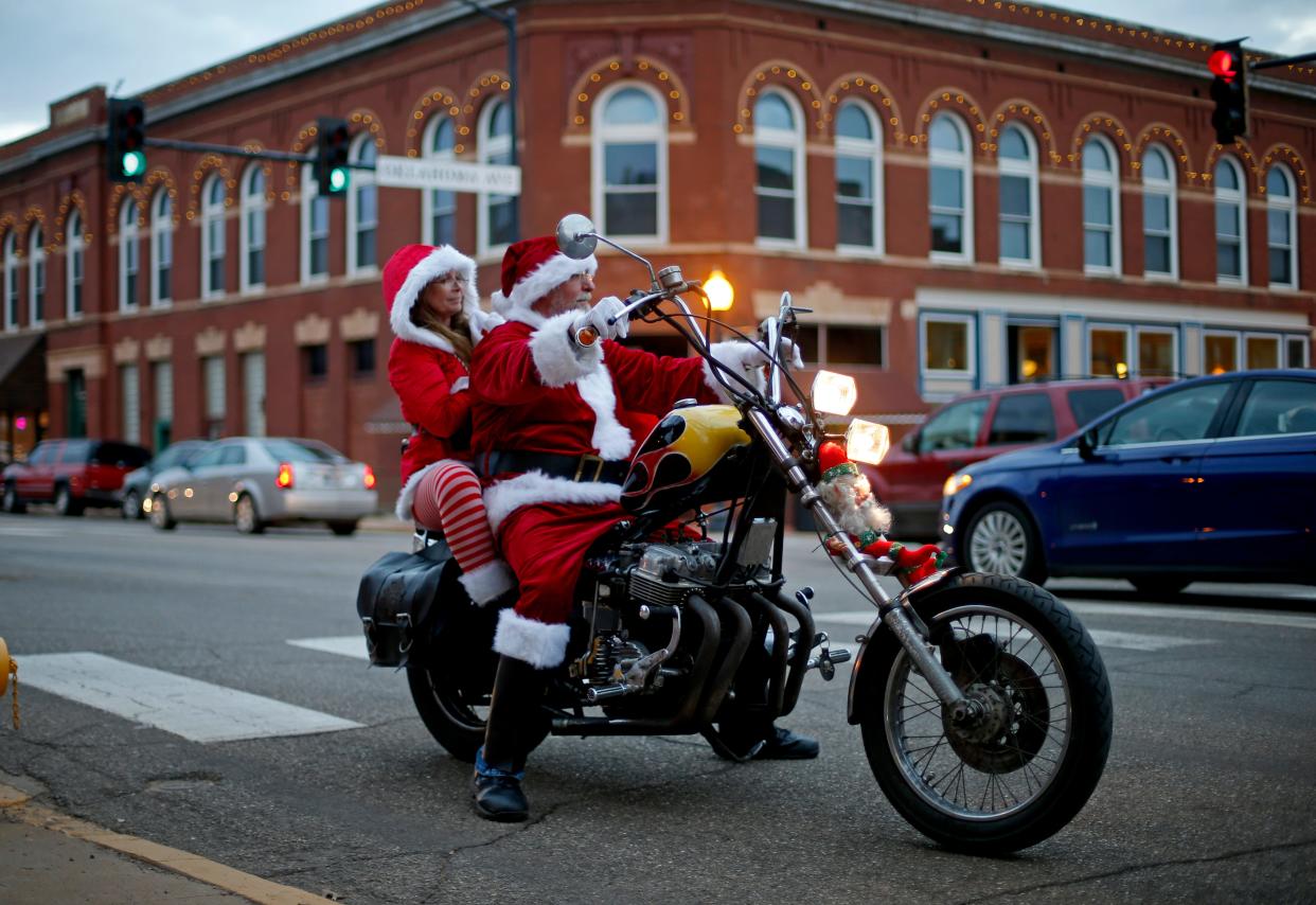 A couple dressed as Santa and Mrs. Claus ride a motorcycle through downtown Guthrie during Guthrie’s Victorian Walk December 14, 2014.