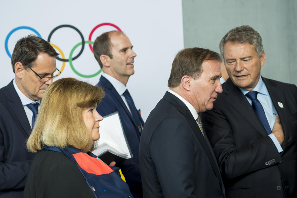 Swedish Prime Minister Stefan Lofven, right, reacts next to Gunilla Lindberg, IOC member of Sweden, left, during the first day of the 134th Session of the International Olympic Committee (IOC), at the SwissTech Convention Centre, in Lausanne, Switzerland, Monday, June 24, 2019. The host city of the 2026 Olympic Winter Games will be decided during the134th IOC Session. Stockholm-Are in Sweden and Milan-Cortina in Italy are the two candidate cities for the Olympic Winter Games 2026. (Jean-Christophe Bott/Keystone via AP)