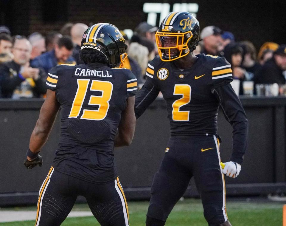 Missouri Tigers defensive back Daylan Carnell (13) celebrates with defensive back Ennis Rakestraw Jr. (2) after intercepting the ball against the Arkansas Razorbacks during the second half at Faurot Field at Memorial Stadium in Columbia, Missouri, on Nov. 25, 2022.